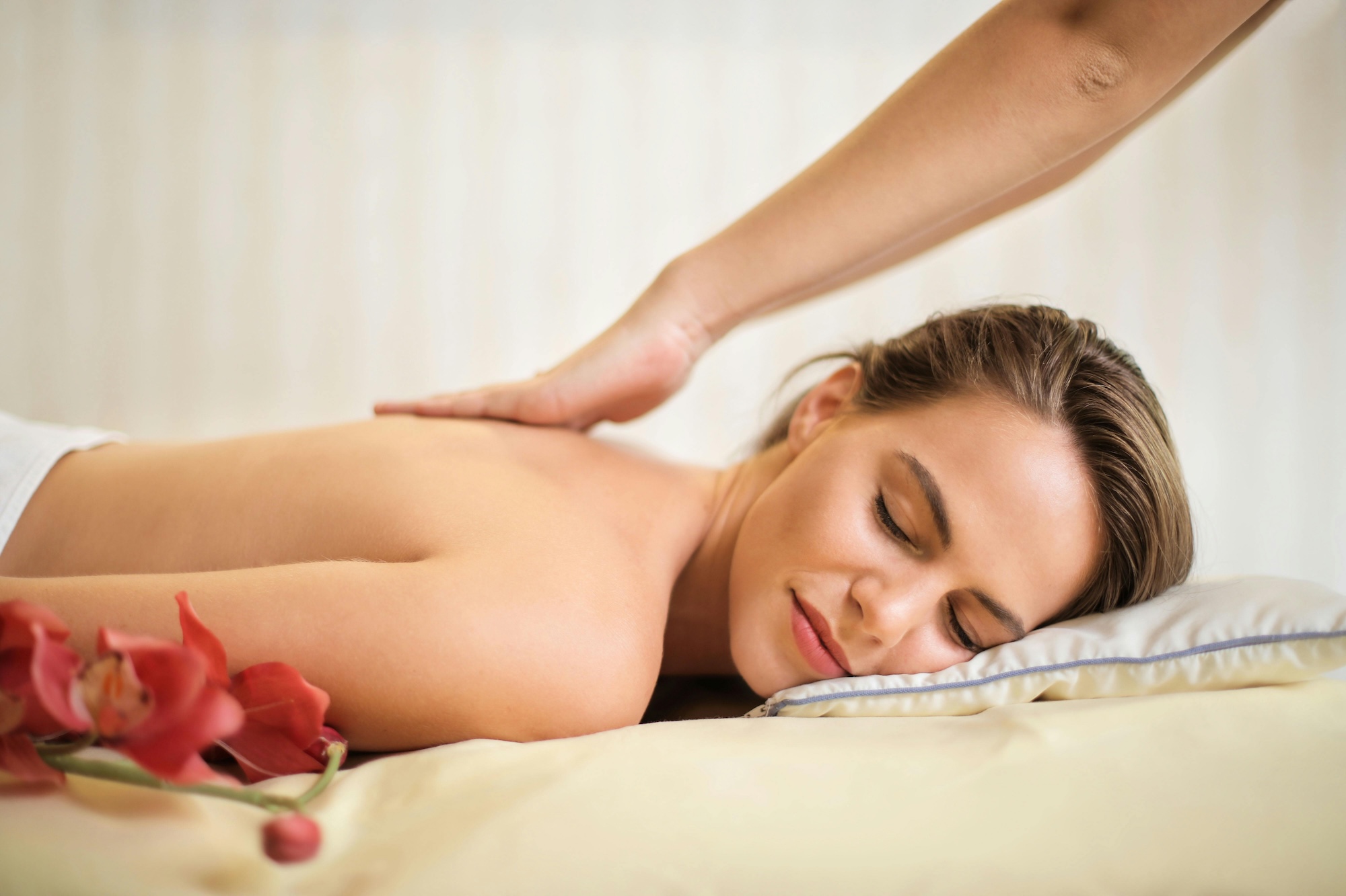 Woman Lying on Bed Getting Massage